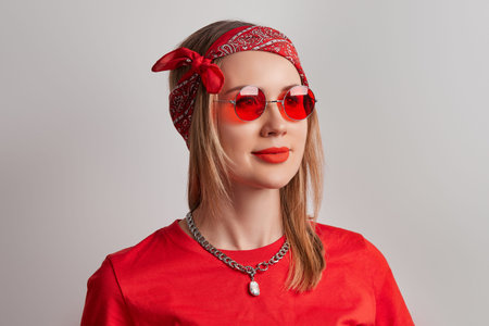 Beautiful young adult woman with red lipstick on gray background. Retro red clothes look