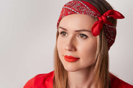 Beautiful young adult woman with red lipstick on gray background. Retro red clothes look. Shopping sale conceptの写真素材