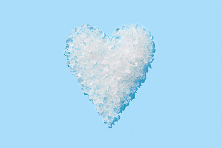 Crushed ice in heart shape on blue background. Summer refreshment conceptの写真素材
