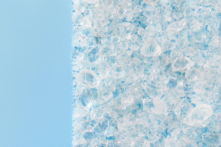 Close up crushed ice in sunlight on blue with copy space. Summer background refreshment conceptの写真素材