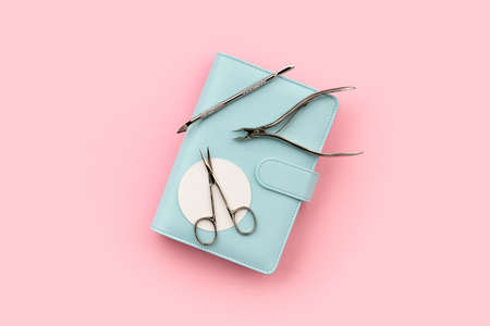 Flat lay top view tools for manicure and notepad on pink backgroundの写真素材