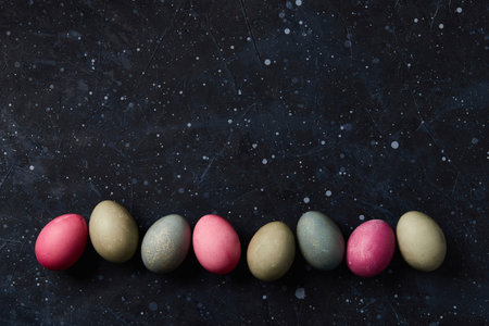 Dyed eggs on black background. Easter celebration conceptの写真素材