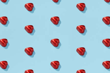 Valentine greeting card with heart shaped chocolate candy on blue background. Valentines day romantic celebration creative layoutの写真素材