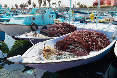 HURGHADA, EGYPT - FEBRUARY 19, 2022: Fishing boat moored at the harbor. Fishnets ready go to sea for fishing.のeditorial素材
