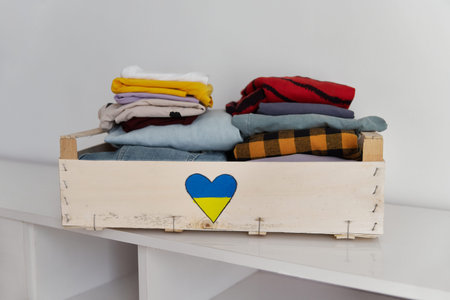 Help volunteering donation concept. Donation box full of clothes at home