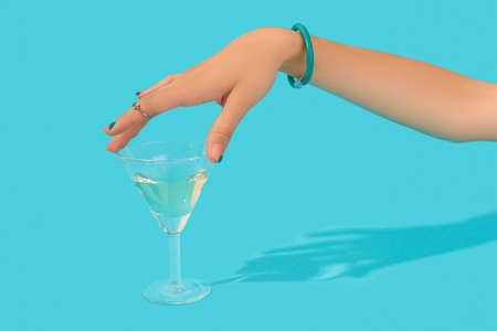 Beautiful groomed womans hand with fashionable ring touch glass of cocktail on blue backgroundの写真素材
