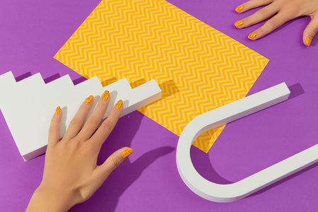 Manicured womans with trendy nail design on purple background