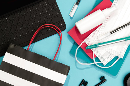 Keyboard Stationery and Hand Sanitizer on Blue Table