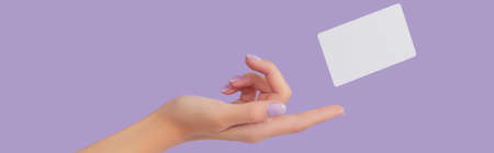 Blank business card levitate on lavender background with womans handの写真素材