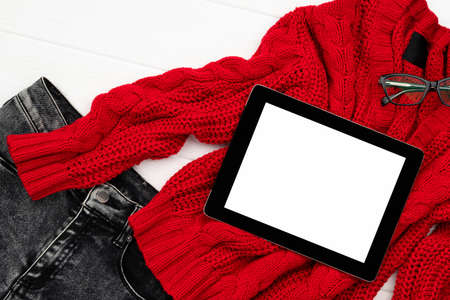Flat lay top view womens autumn clothes with tablet on white backgroundの写真素材