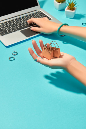 Womans hands with fashion clothes and accessories on blue background