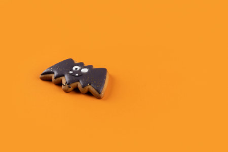 Halloween homemade gingerbread on orange background with copy space