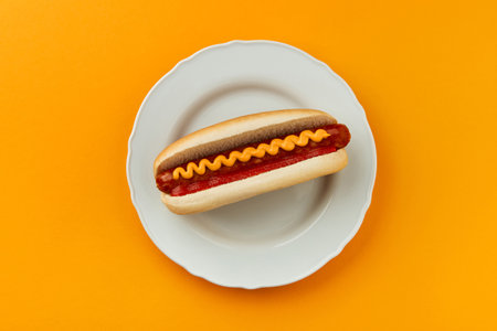 Classic hot dog with wurst, ketchup and mustard on orange background. Menu for restaurantの写真素材