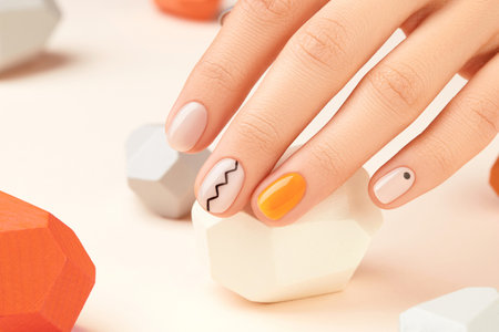 Manicured womans hand close up on beige background. Minimal spring autumn nail designの写真素材