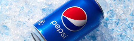 Kyiv, Ukraine - November 13, 2021. Pepsi can in crushed ice. Soft drink summer refreshment concept