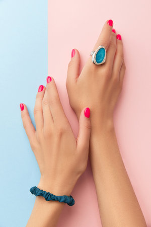 Womans hands with trendy manicure on double pink and blue background. Beauty salon conceptの写真素材