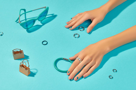 Womans hands with fashion clothes and accessories on blue backgroundの写真素材