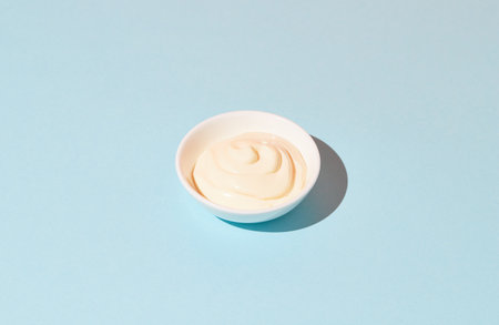 Fresh tasty mayonnaise sauce on blue backgroundの写真素材