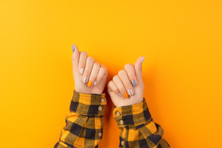 Beautiful womans hands with minimal nail design on orange background. Manicure, pedicure beauty salon conceptの写真素材