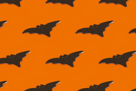 Pattern made with napkin in the shape of a bat on an orange background with copy spaceの写真素材