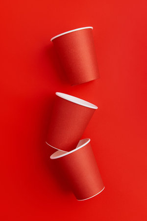 Paper cups on a red background. Eco friendly, sustainable lifestyle.
