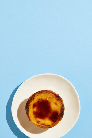 Traditional Portuguese egg tart dessert Pasteis Pastel de nata or Pastels de Belem on the plate over...