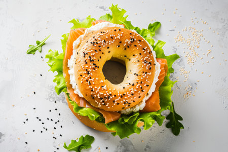 Top view on Salmon Bagel Sandwich with cheese, lettuce and arugula over white backgroundの素材