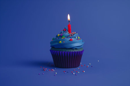 Birthday cupcake with burning candle on blue background. 3d illustrationの素材