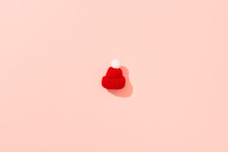 Toy mini hat on a pink background with long shadows.の写真素材