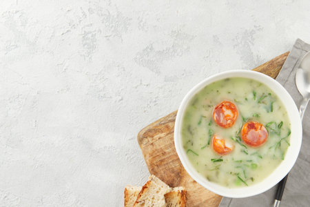 Portuguese style soup Caldo Verde with bread on gray background with copy space