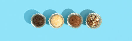 Typical Brazilian sweet brigadeiro. Assorted flavors of candies in a line on a blue background