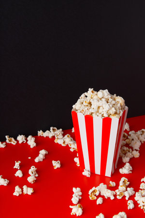 Striped box with popcorn on a red and black backgroundの写真素材