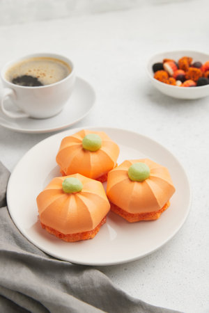 White ghost shaped meringue cookies with black eyes, stacked on a dark gray plate