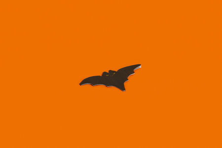 Napkin in the shape of a bat on an orange background with copy space