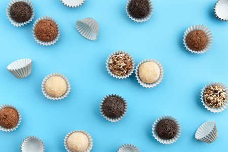 Typical Brazilian sweet brigadeiro. Assorted flavors of candies in a line on a blue backgroundの写真素材