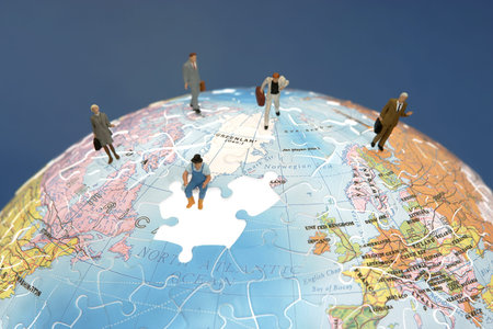 Business figurines standing on a globe の写真素材