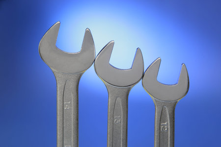 Tree steel wrenches of different size on blue background 