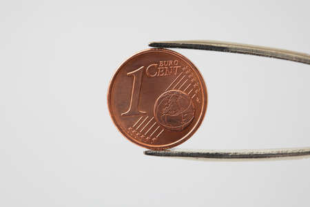 Euro cent being pinched with pair of tweezersの写真素材