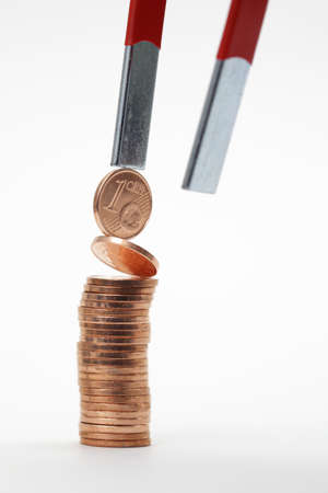 Euro coins attracted by a magnetの写真素材