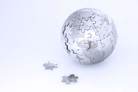 Metal puzzle globe isolated on white background, in blue lightの写真素材