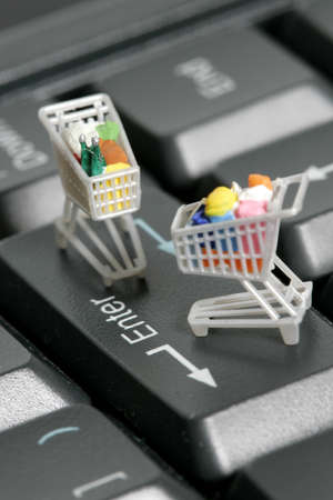 Miniature shopping carts on a computer keyboard の写真素材