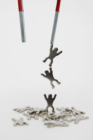 Magnet Lifting Metal Figures on white backgroundの写真素材