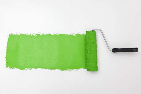 Green paint roller on white backgroundの写真素材
