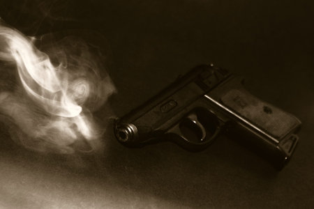 Pistol, lying on the floor, still smokingの写真素材