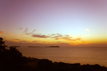 view from the rocks of the north-western coast of Ibiza into some small islands in the mediterranean seaの写真素材