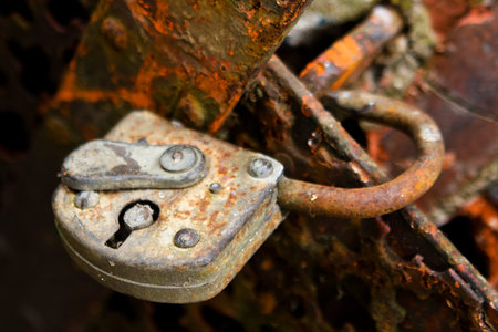 broken rusty padlock at rusty iron bars