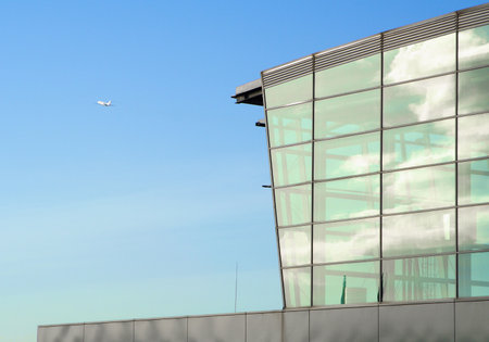 modern airport building and rising plane in blue skyのeditorial素材