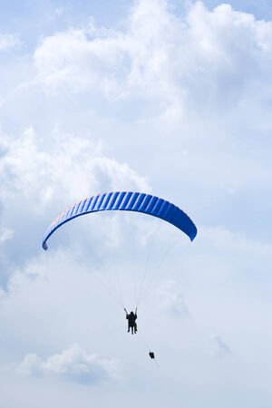 paraglider with two people being lifted with a winchの写真素材