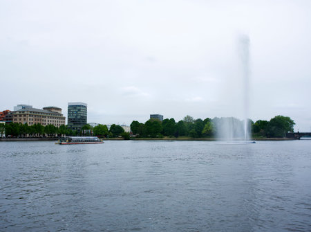 tourist boat on the Binnenalster lake at hamburg, fountain spraying