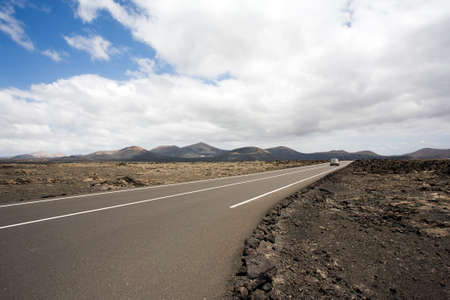 car driving through the desert at Timanfaya national park, Lanzaroteの写真素材